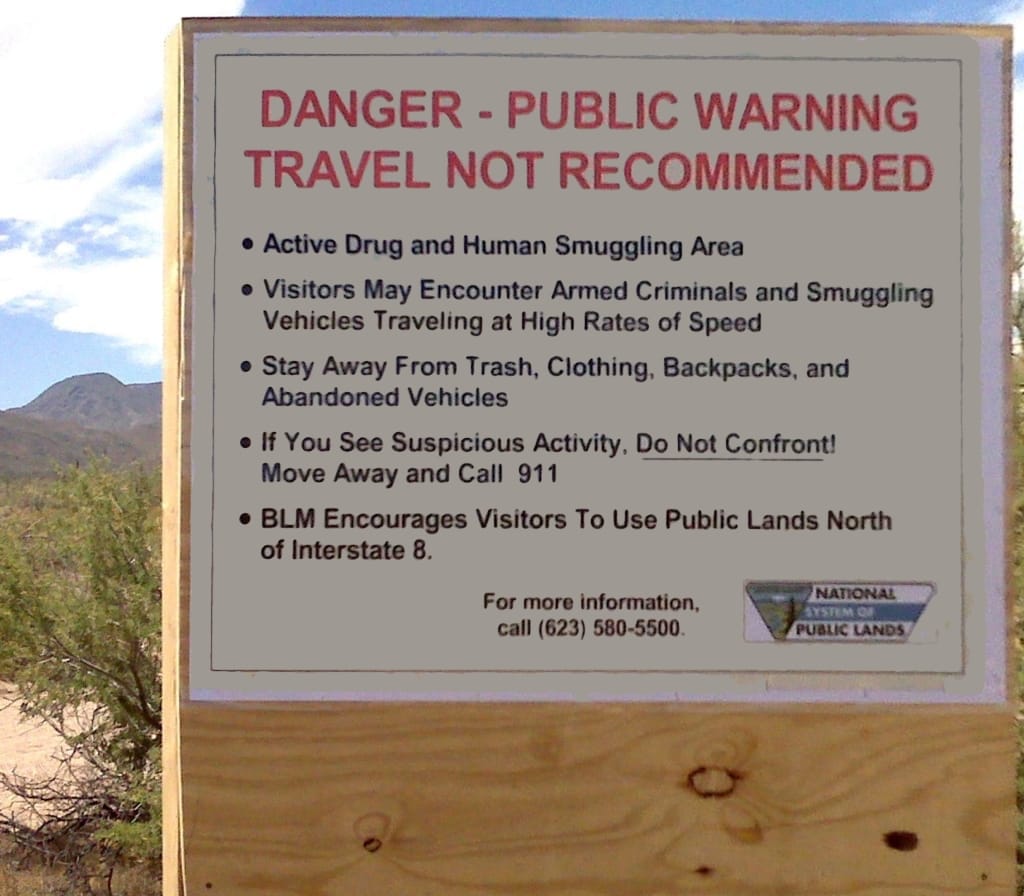 Arizona border sign: Danger --- public warning. Travel not recommended. Active drug and human smuggling area. Armed criminals.